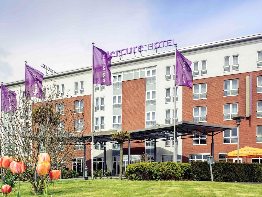 a hotel with purple flags in front of a building at Mercure Kamen Unna in Kamen
