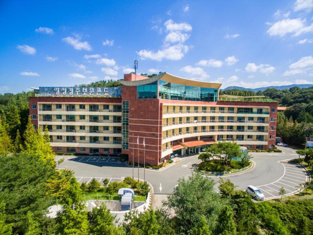 a large building with a parking lot in front of it at Gyeongju Ilsung Condo in Gyeongju