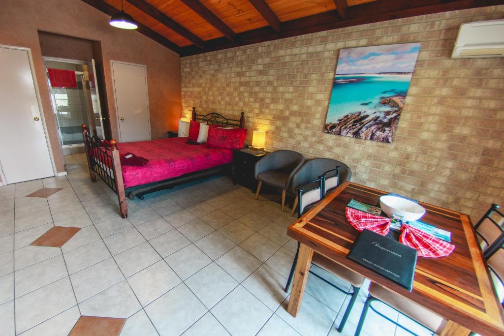 a bedroom with a bed and a table in a room at Esperance Foreshore Apartments in Esperance