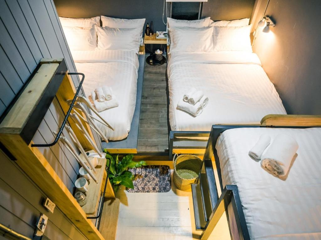 two twin beds in a small room with twoperate floors at Zeds Hostel Bangkok in Bangkok