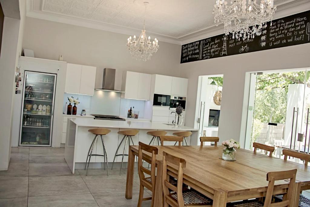 uma cozinha e sala de jantar com uma mesa de madeira e cadeiras em Cape Karoo Guesthouse em Beaufort West