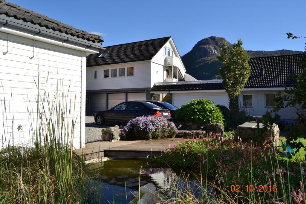 uma casa com um lago em frente a uma casa em Fossanmoen em Forsand