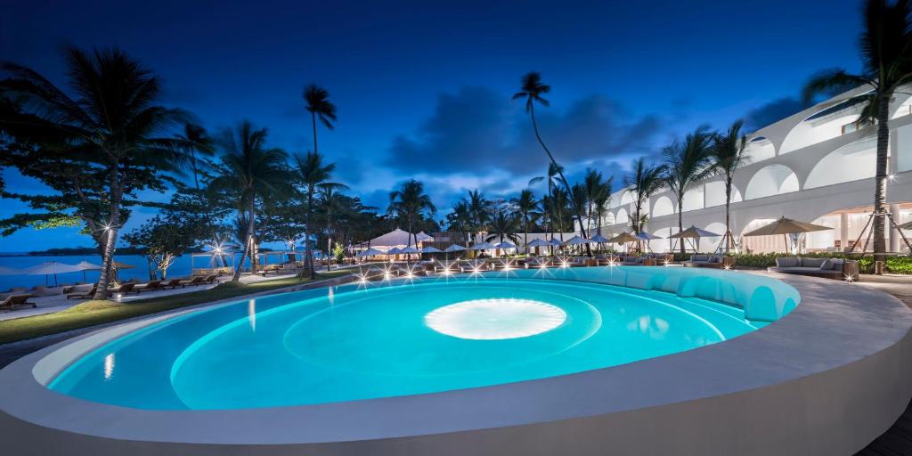 a swimming pool in a resort at night at SALA Samui Chaweng Beach Resort in Chaweng