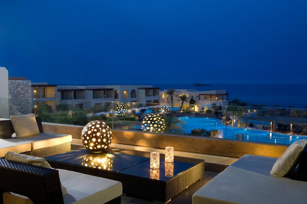 a patio with a view of a pool at night at Aquagrand Exclusive Deluxe Resort Lindos - Adults only in Lindos