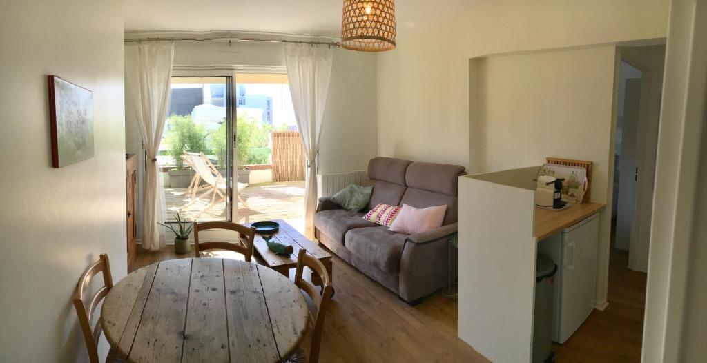 ein Wohnzimmer mit einem Tisch und einem Sofa in der Unterkunft Le Wim'Heureux Terrasse in Wimereux