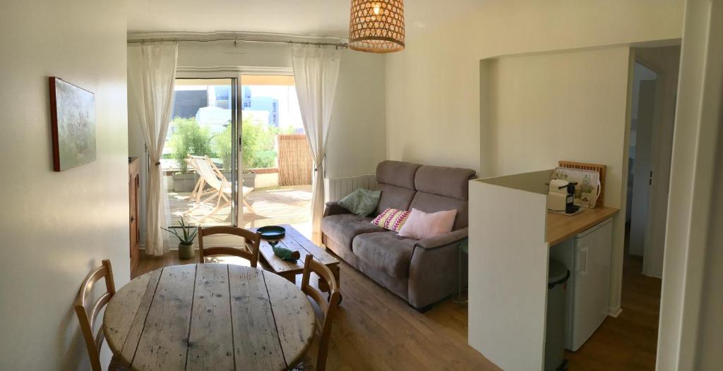 sala de estar con mesa y sofá en Le Wim'Heureux Terrasse en Wimereux