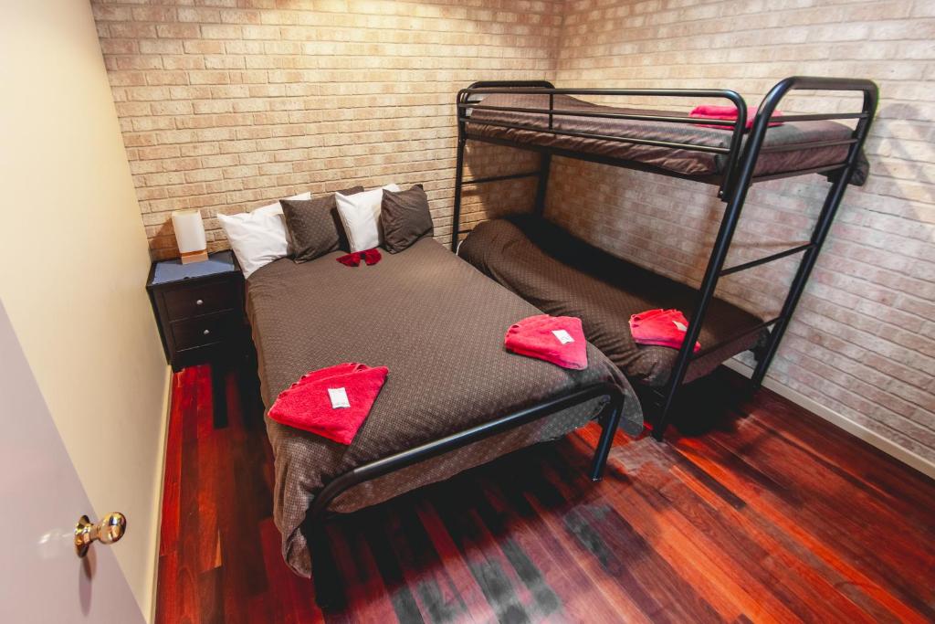 a bedroom with a bunk bed with red pillows on it at Esperance Foreshore Apartments in Esperance