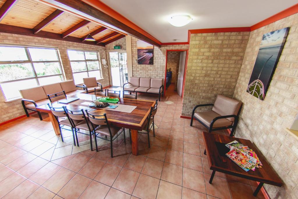 a dining room with tables and chairs and windows at Esperance Foreshore Apartments in Esperance
