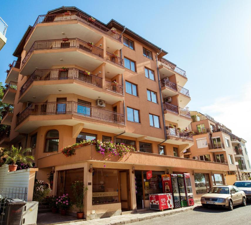 ein großes Apartmenthaus mit einem davor geparkt in der Unterkunft Hotel Orchidea in Sozopol