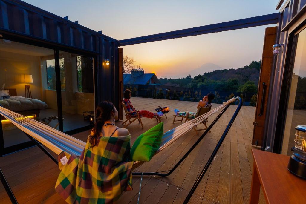 a group of people sitting in hammocks on a house at Fujino Kirameki Fujigotemba in Gotemba