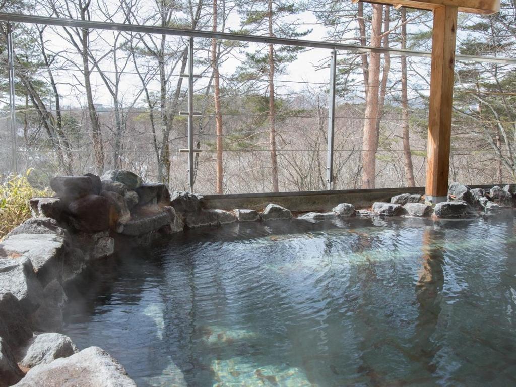 uma grande piscina de água com um gazebo em Itoen Hotel Kusatsu em Kusatsu