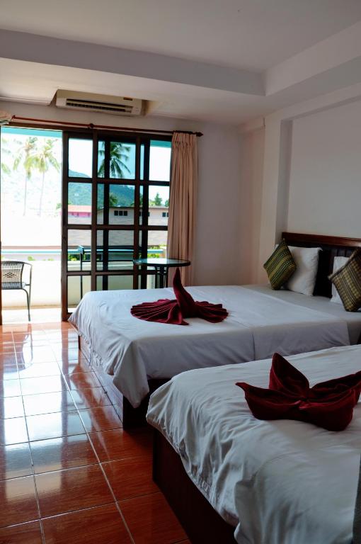 a hotel room with two beds with red ribbons on them at Bonny Hotel 4 Floors No Elevator in Lamai
