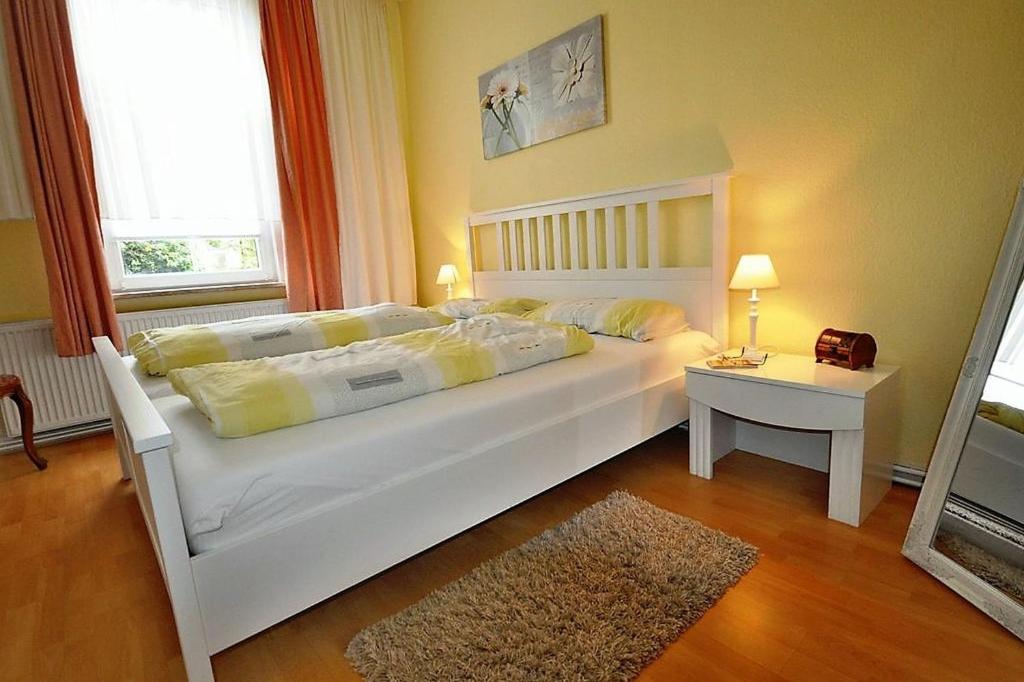 バート・ハルツブルクにあるHacienda Susanaのテーブル付きの客室で、白い大型ベッド1台が備わります。