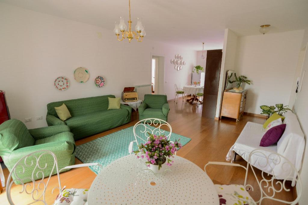 un soggiorno con divano verde e tavolo di S'Alighera Guest House ad Alghero