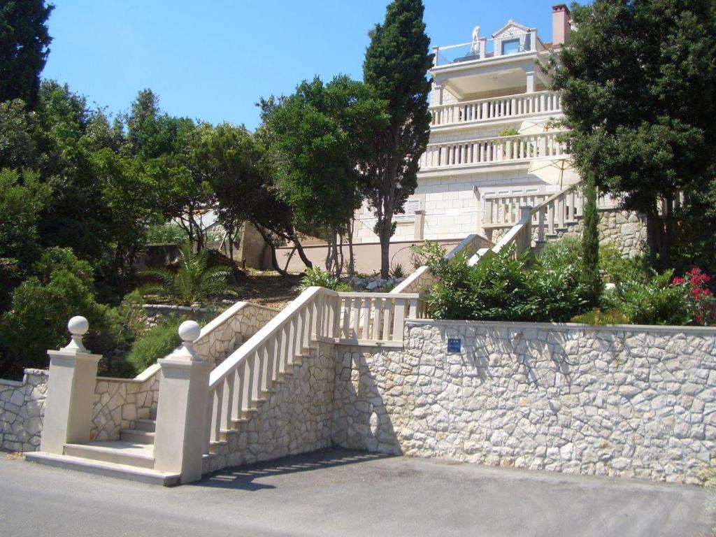 uma parede de pedra com uma escada em frente a um edifício em Villa Jade Apartments FRONT ROW SEA VIEW - WALK TO KORCULA OLD TOWN em Korčula