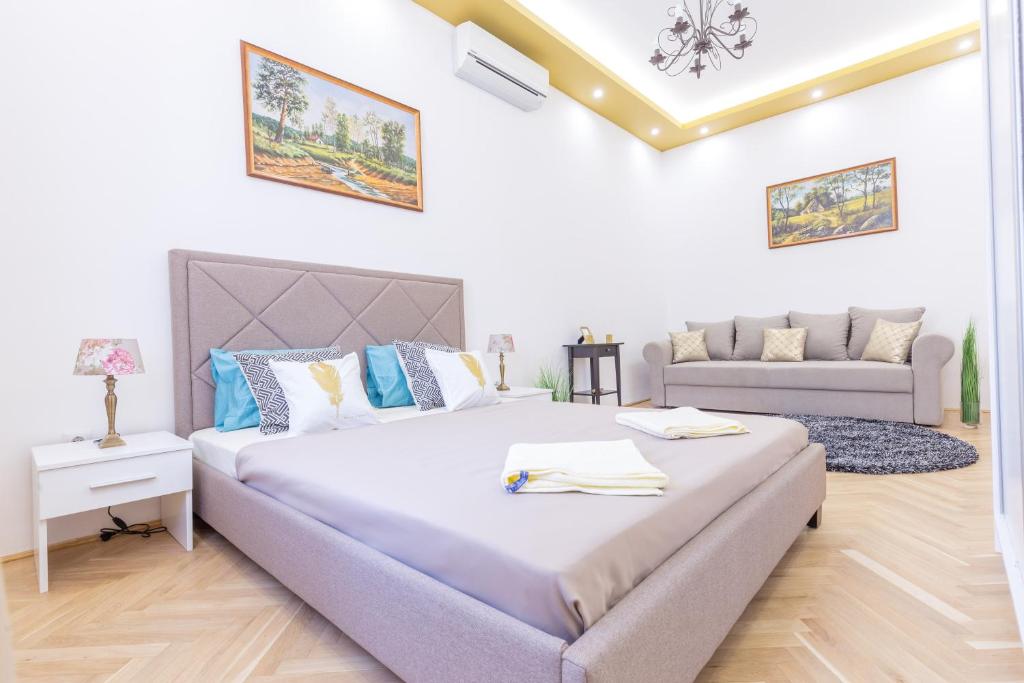 a bedroom with a large bed and a couch at Real Apartments Zoltán in Budapest