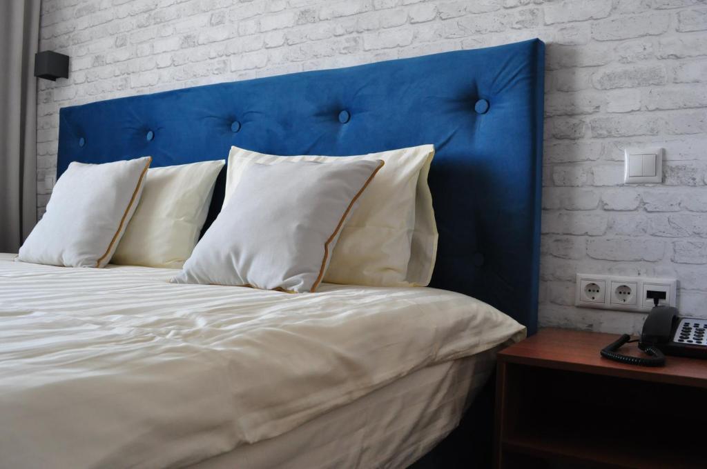 コロリョフにあるLOFT Boutique Hotelのベッド1台(青いヘッドボード、白い枕付)