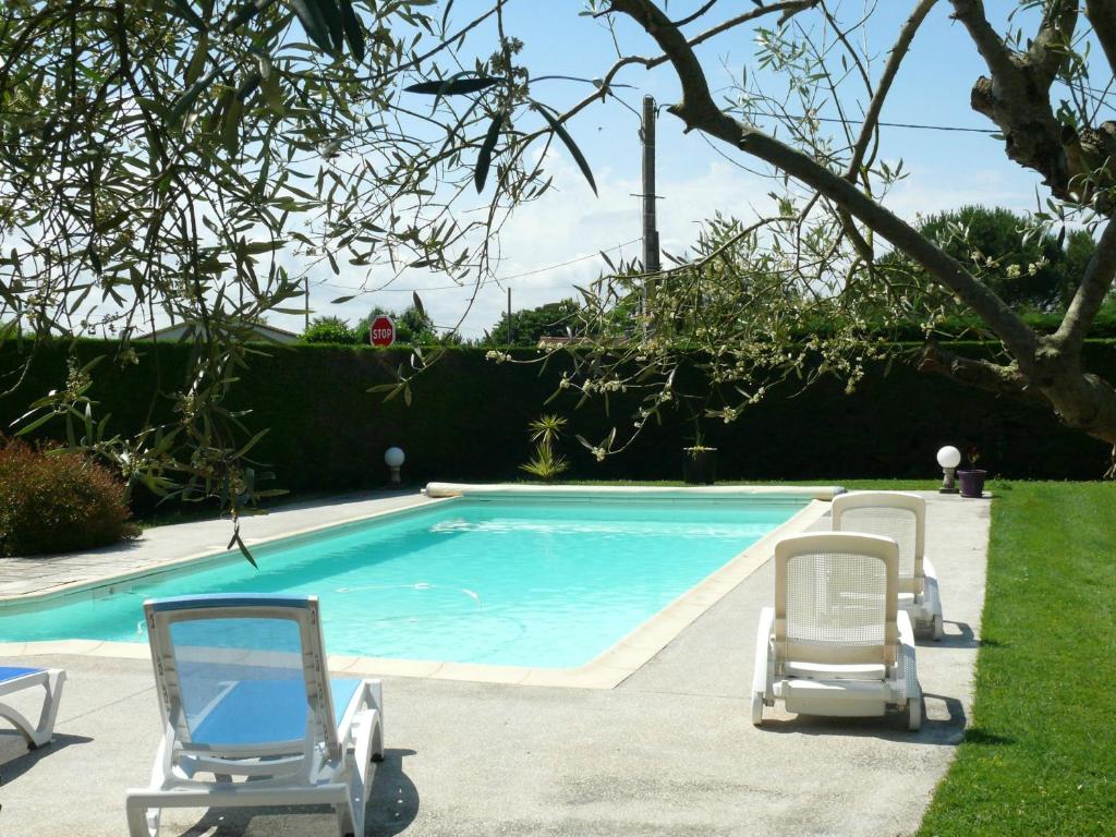 - deux chaises et une piscine dans la cour dans l'établissement Gîte du Clos de la Vigne, à Montreuil