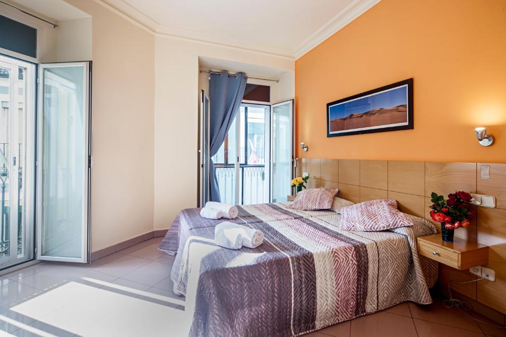a hotel room with a bed and a television at INTER Puerta del Sol Pension in Madrid