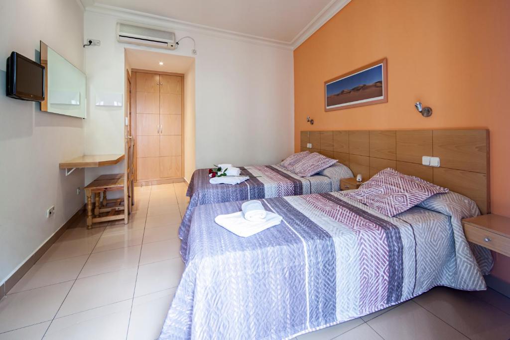 A bed or beds in a room at Hostal Inter Puerta del Sol AUTO CHECK IN