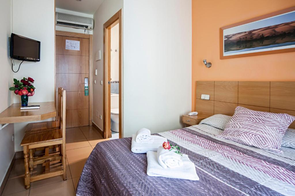 A bed or beds in a room at Hostal Inter Puerta del Sol AUTO CHECK IN