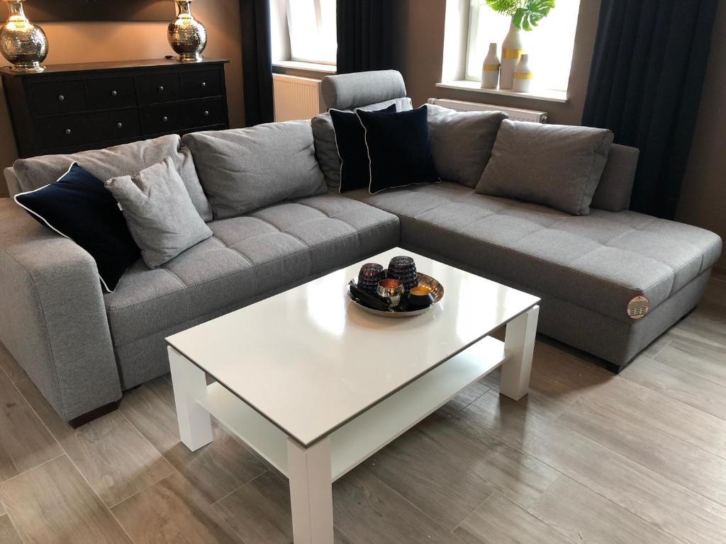 ein Wohnzimmer mit einem Sofa und einem weißen Couchtisch in der Unterkunft Wohnung im Stadtzentrum in Cloppenburg