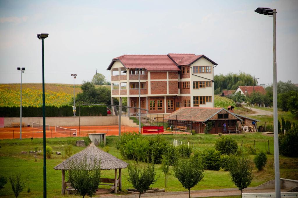 a large building in front of a park with a building at Pansion Budimir in Đakovo