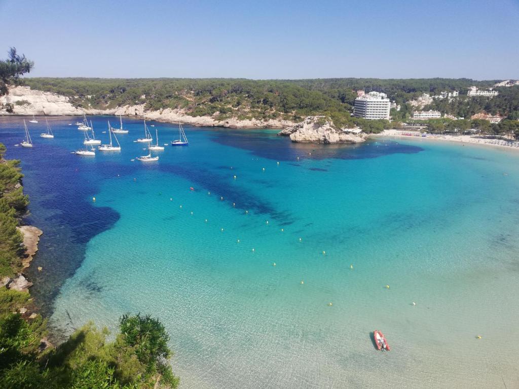 an aerial view of a harbor with boats in the water at Menorca beach in Cala Galdana