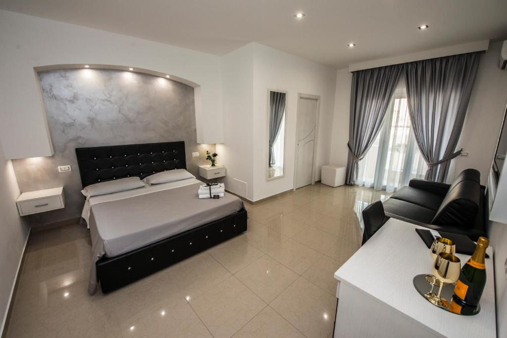 una grande camera da letto con un letto e un divano di La Suite Tropea a Tropea