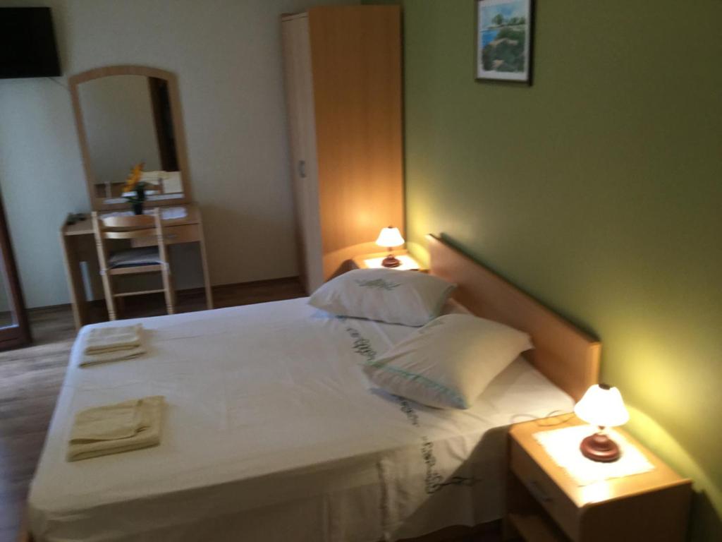 sypialnia z dużym łóżkiem z 2 lampami w obiekcie Apartmani Jerkovic w Hvarze