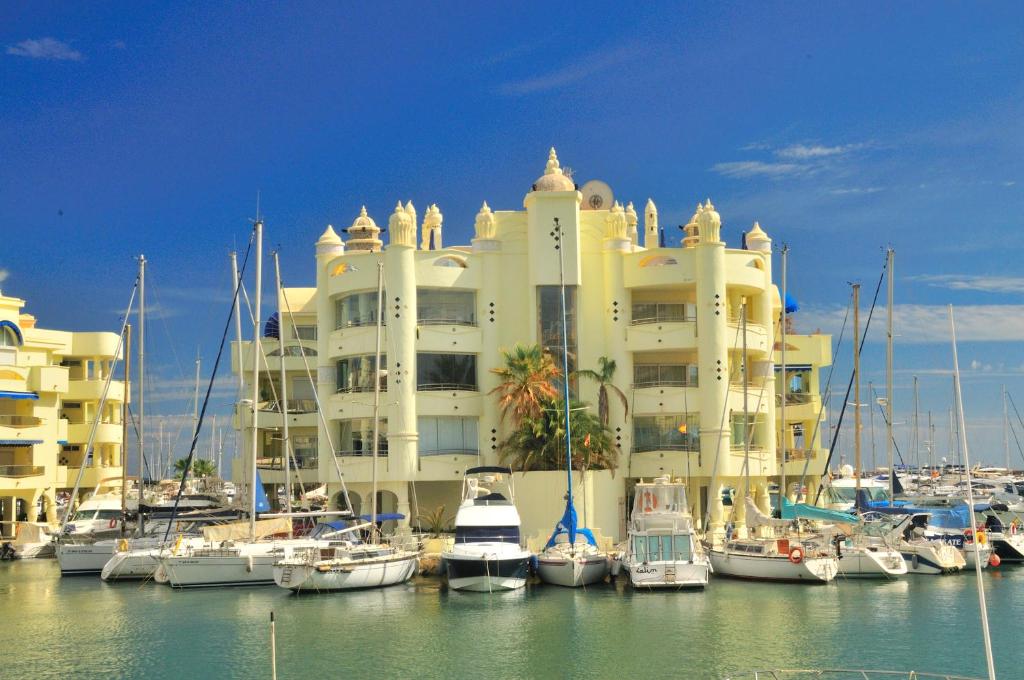a large white building with boats in a marina at Capaldi Luxury Holiday Rentals Puerto Marina Benalmadena in Benalmádena
