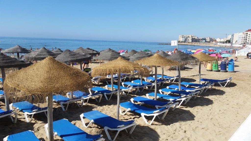 トレビエハにあるApartamento a 150m de la playa en Torreviejaの浜辺の椅子・傘