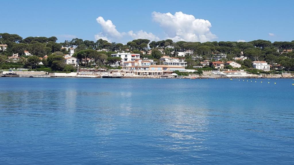 a view of a large body of water with houses at Hotel Miramar- Cap d'Antibes - La Garoupe plage in Antibes