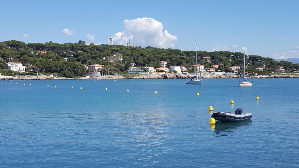 a small boat in a large body of water at Hotel Miramar- Cap d'Antibes - La Garoupe plage in Antibes