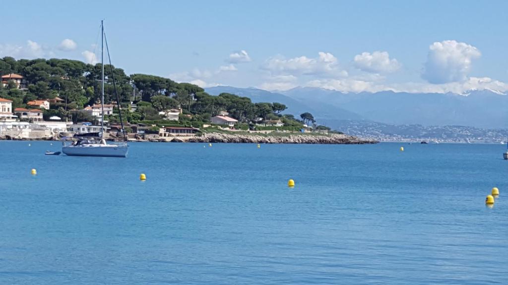 a boat in a large body of water at Hotel Miramar- Cap d'Antibes - La Garoupe plage in Antibes