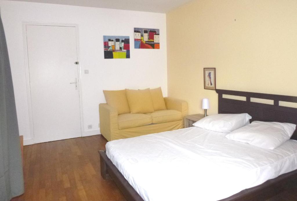 1 dormitorio con 1 cama y 1 silla amarilla en Ti Post, en Groix