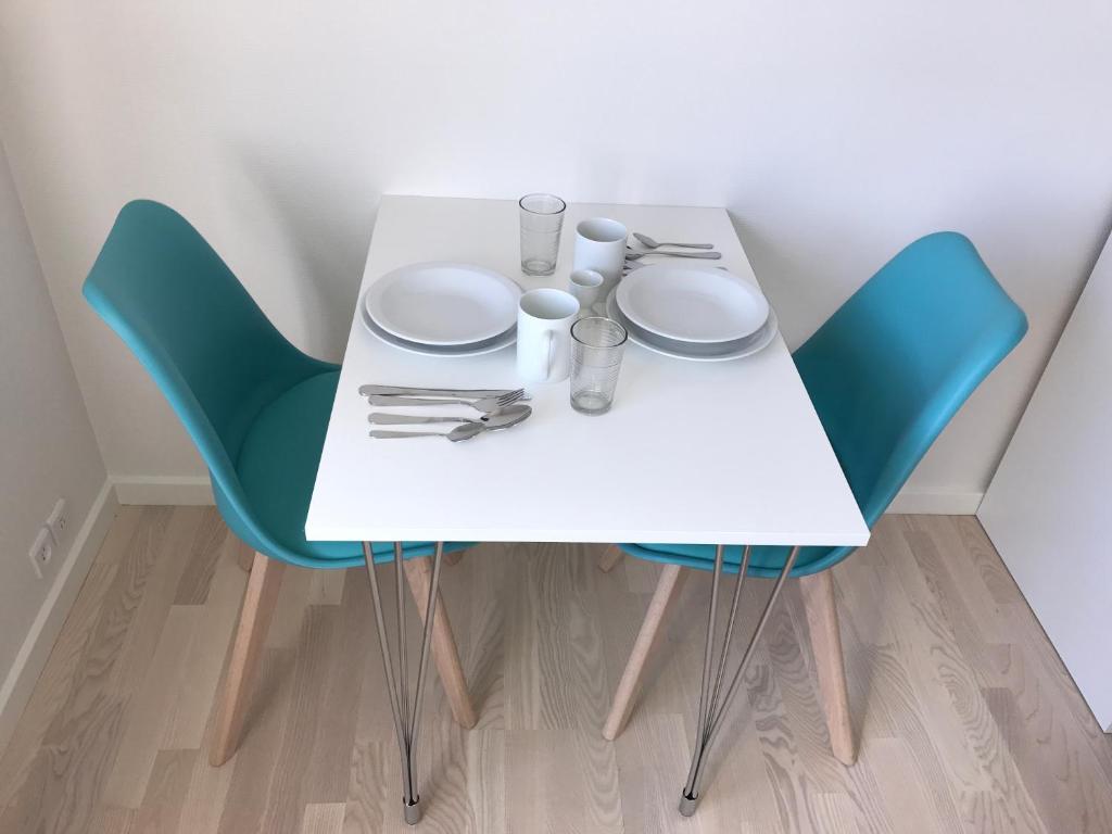 a white table and chairs with plates and glasses on it at Hotel Nuka in Ilulissat