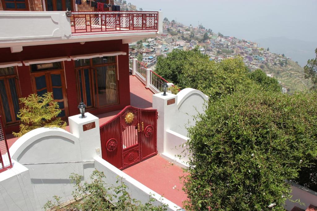 a house with a red door and a balcony at Chandruma Cottage in Pauri