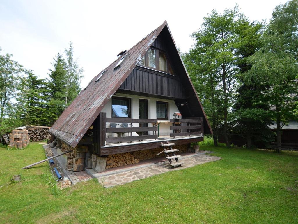 mały domek z dachem krytym strzechą na polu w obiekcie Holiday home in the Ore Mountains near chairlift w mieście Loučná pod Klínovcem
