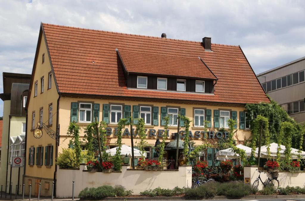 a yellow building with a red roof at Brauereigasthof Dachsenfranz in Zuzenhausen