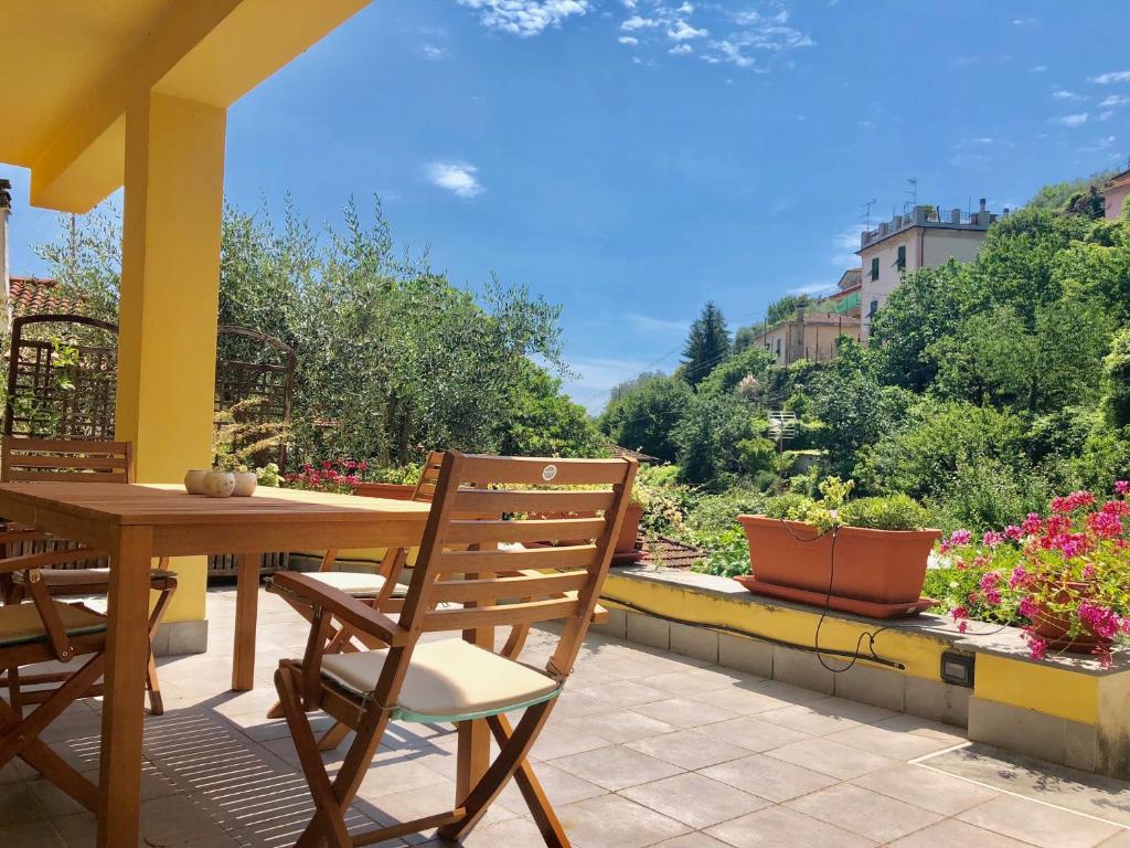 drewniany stół i krzesła na patio z kwiatami w obiekcie Casa Del Cavaliere w mieście La Spezia