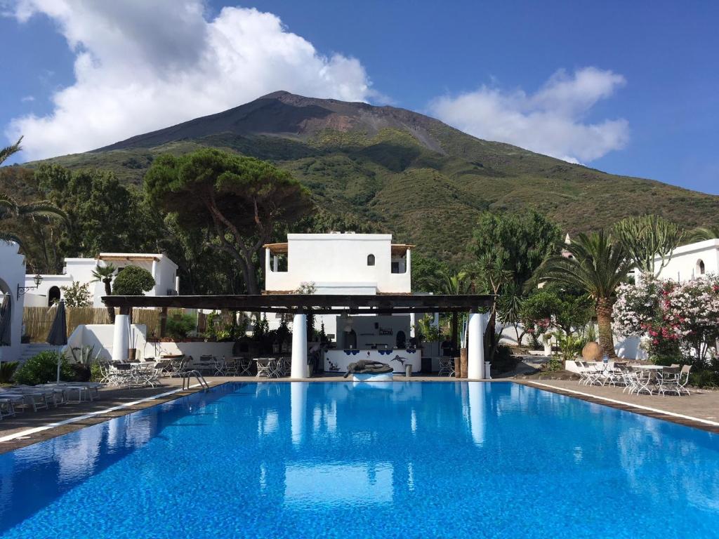 a swimming pool with a mountain in the background at Hotel La Sciara in Stromboli