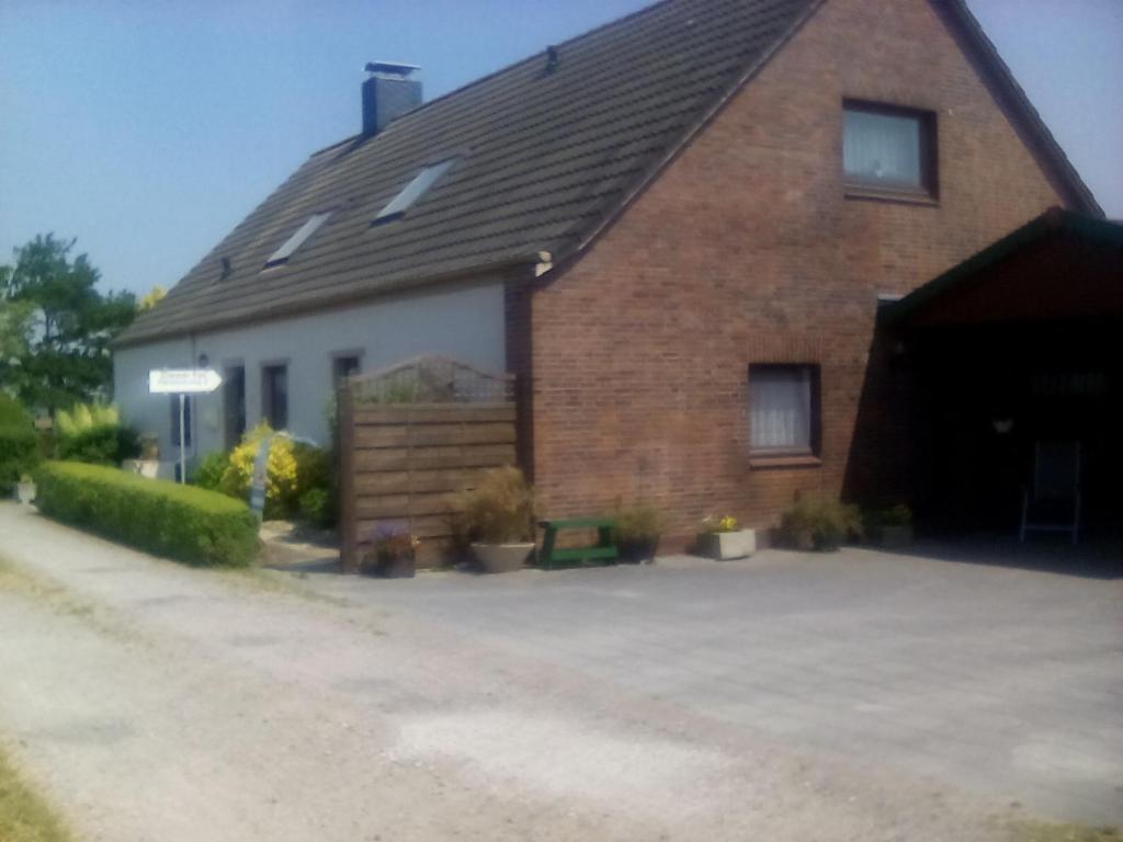 a large brick house with a driveway in front of it at up de Pfahldeichsweg in Neugarmssiel