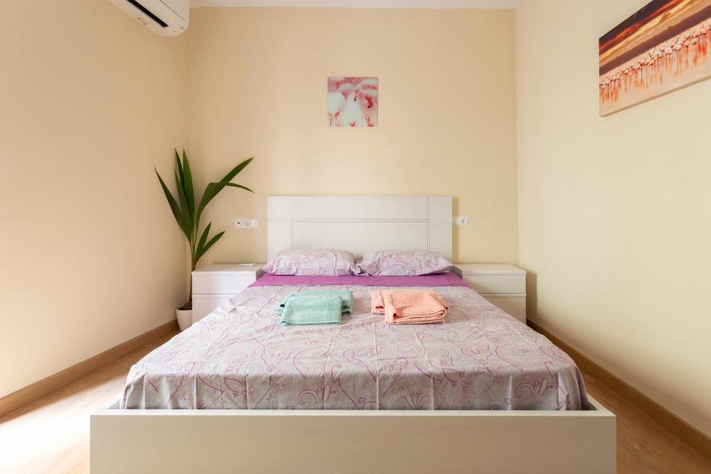 sypialnia z łóżkiem i dwoma ręcznikami na nim w obiekcie Flamingo Apartment w Maladze