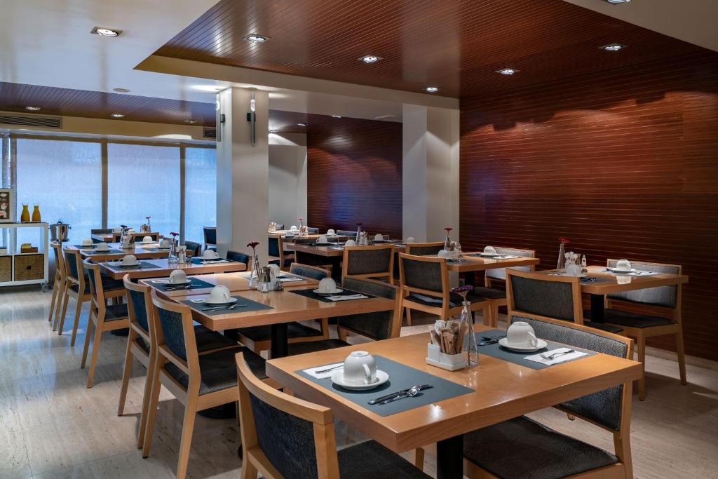 a dining room with wooden tables and chairs at Vincci Puertochico in Santander