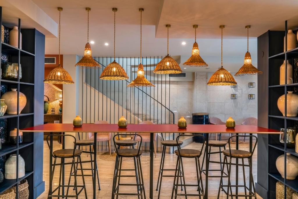 a kitchen with a red bar with stools at Vincci Puertochico in Santander