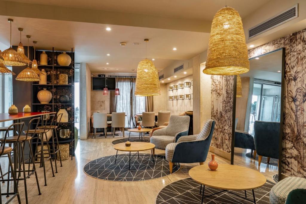 a restaurant with tables and chairs and a bar at Vincci Puertochico in Santander