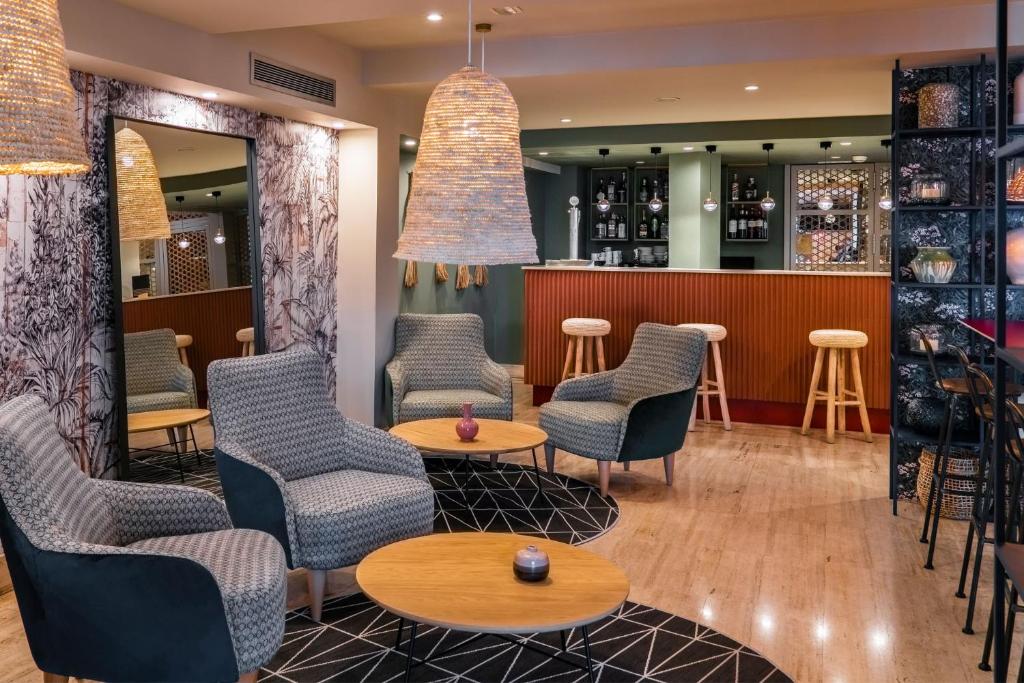 a restaurant with chairs and tables and a bar at Vincci Puertochico in Santander