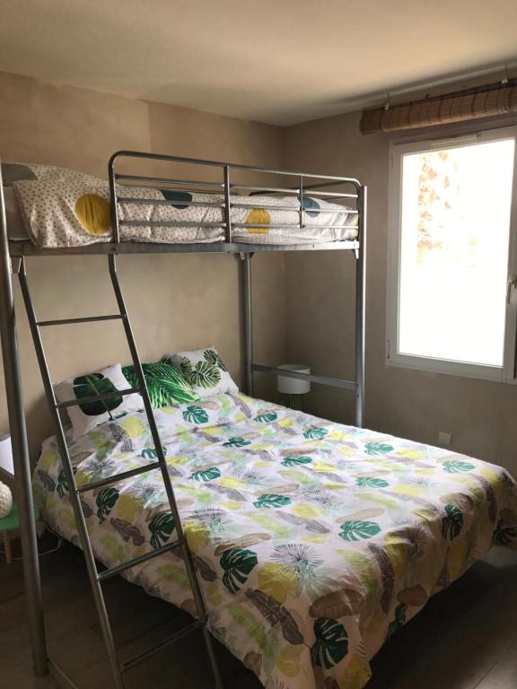 a bedroom with a bunk bed with a floral bedsheet at Résidence Village Marin Catalan TORREILLES PLAGE in Torreilles
