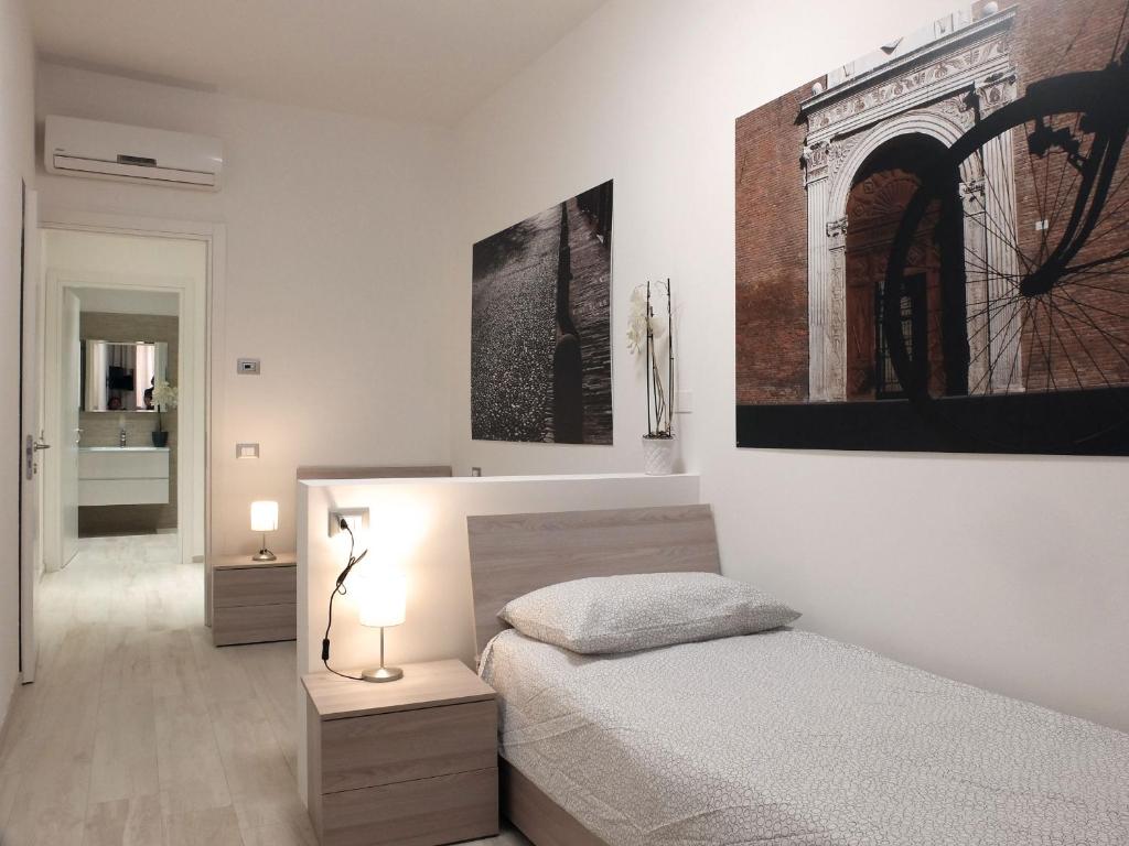 a bedroom with a bed and a painting on the wall at Centro Storico Rooms in Ferrara